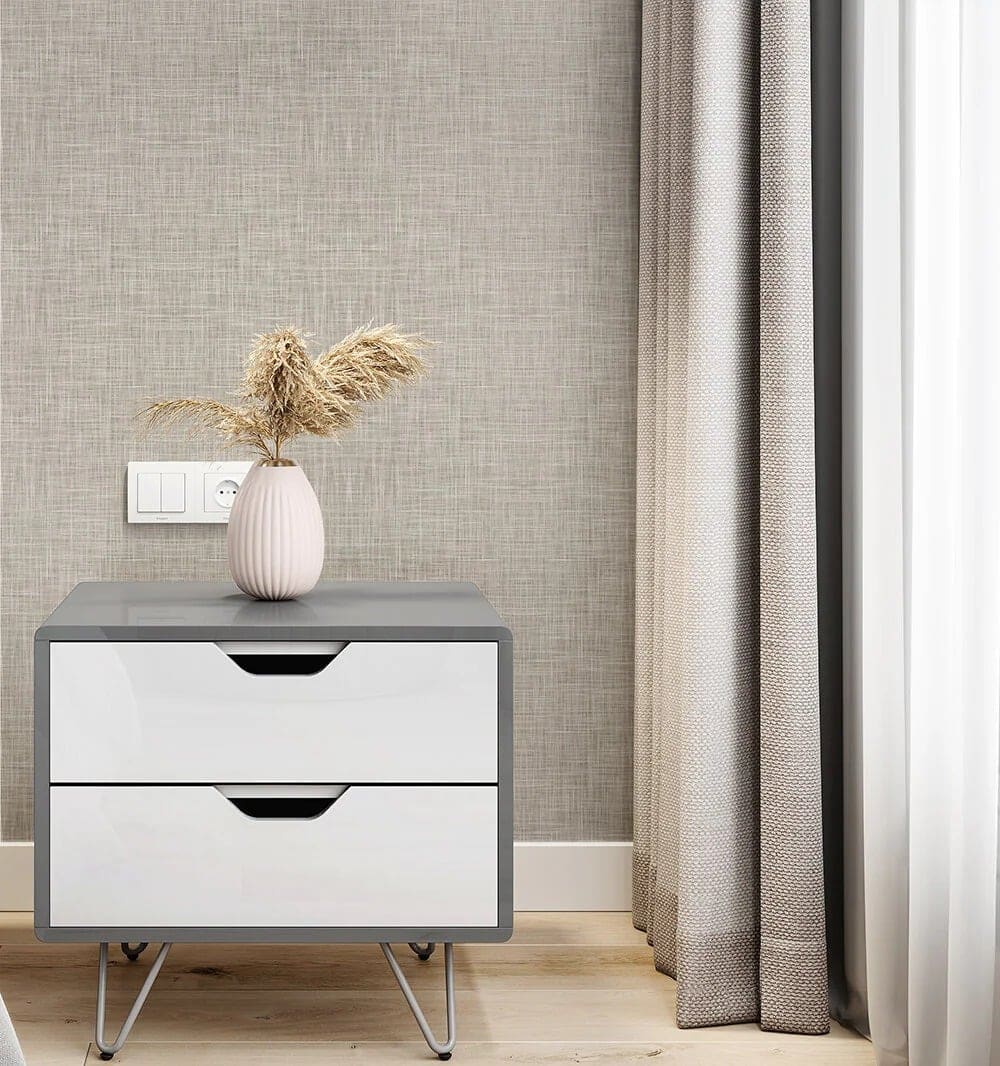 The textured gray wallpaper features various shades of gray with subtle patterns, creating a modern and elegant backdrop behind the bedside table.