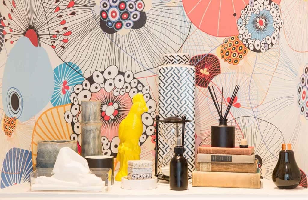 The wallpaper features a colorful, abstract floral design. It includes vibrant colors such as deep blues, rich greens, bold pinks, sunny yellows, and hints of orange. The flowers are artistically rendered with swirling patterns and dynamic shapes.