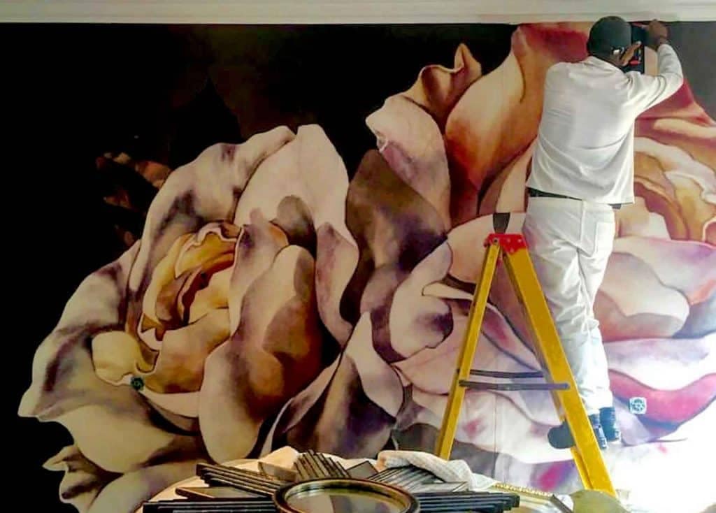 A stunning mural features two blooming roses in muted tones. The detailed wallpaper showcases intricate petals in soft, complementary colors, blending seamlessly into the ambient design. Perfect for an elegant and sophisticated aesthetic.