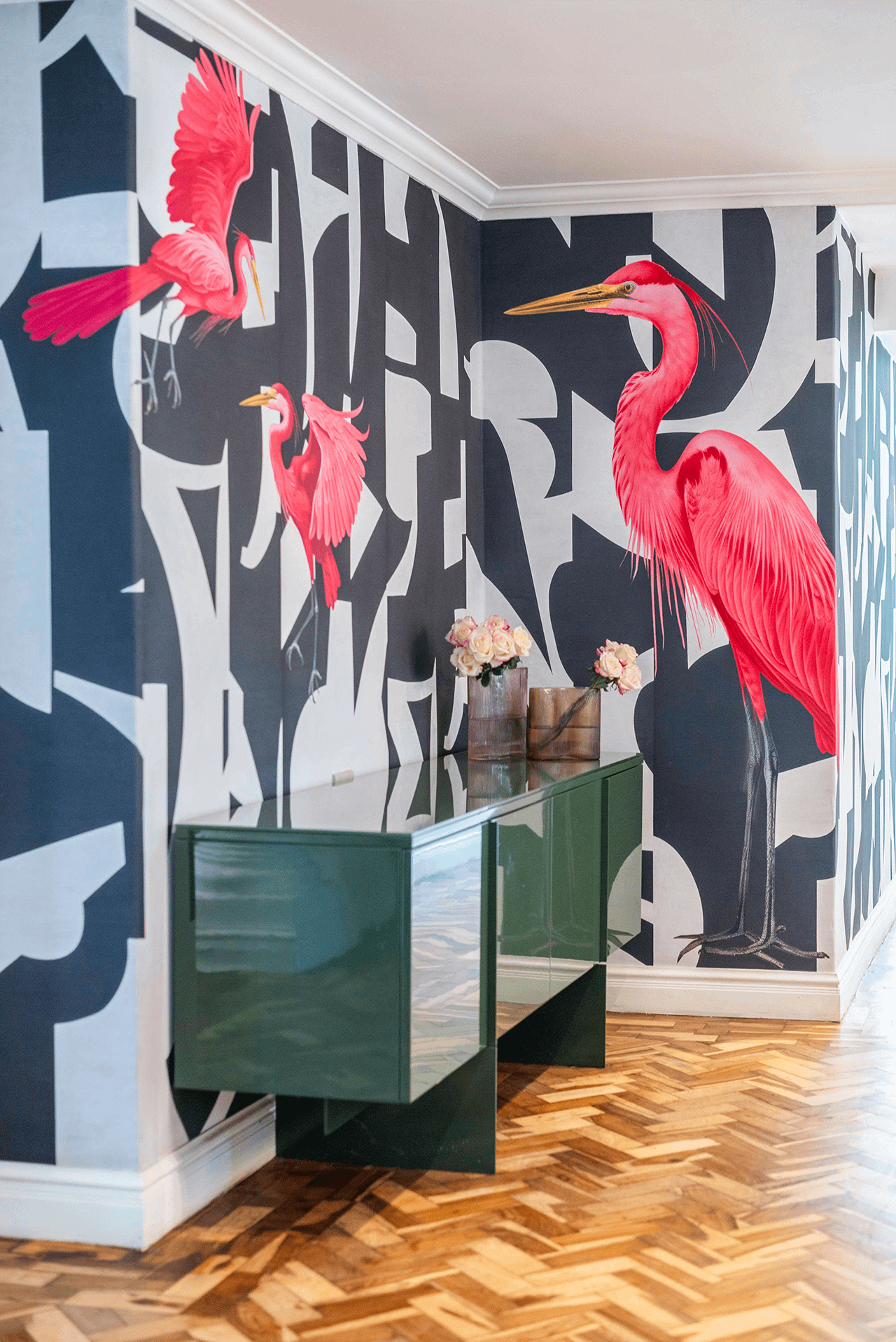 The wallpaper features large pink birds, bold abstract black and white shapes, and a lively pattern. Colors present: pink, black, white.