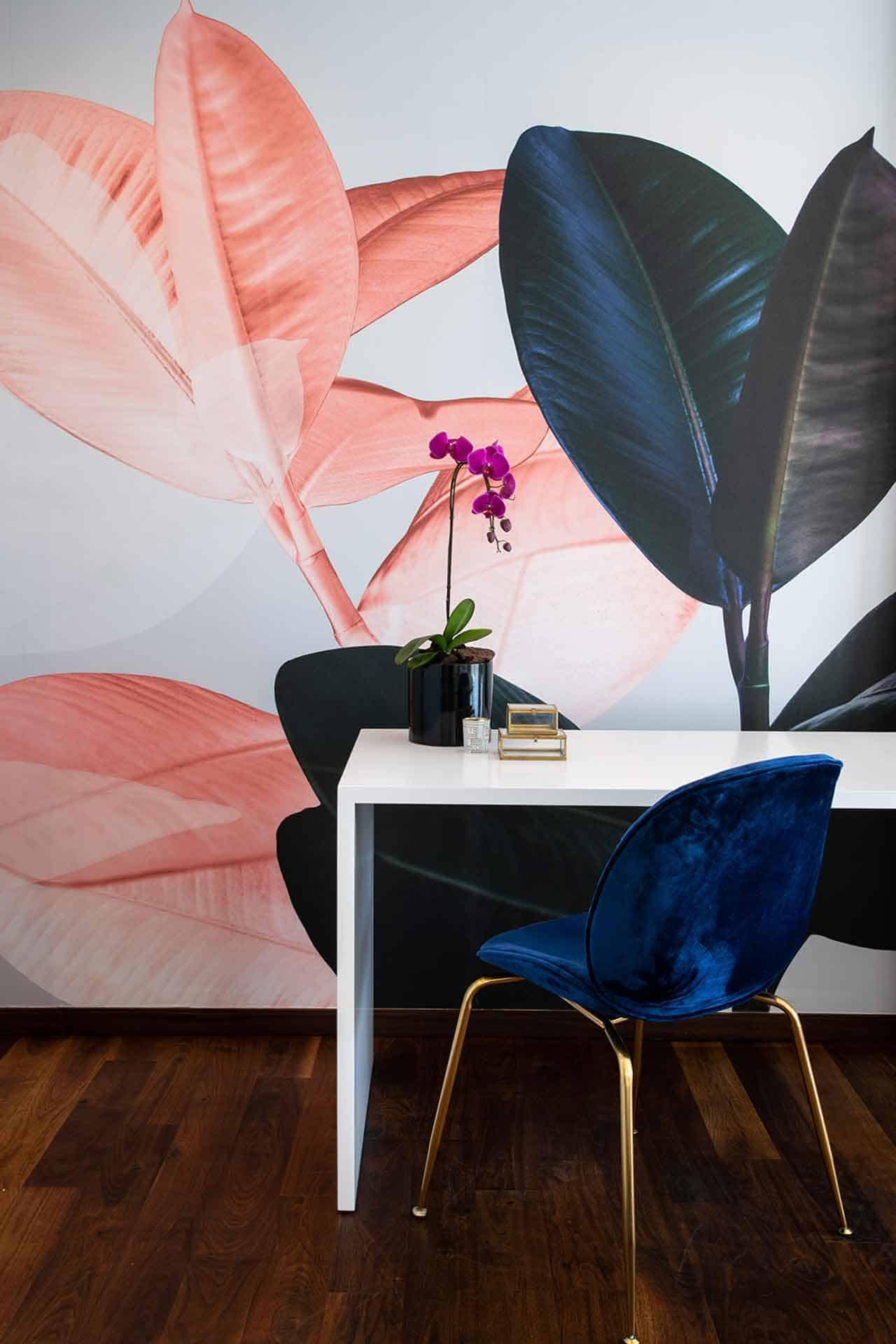 A wall mural showcasing large, colorful tropical leaves in vibrant pink and dark green.