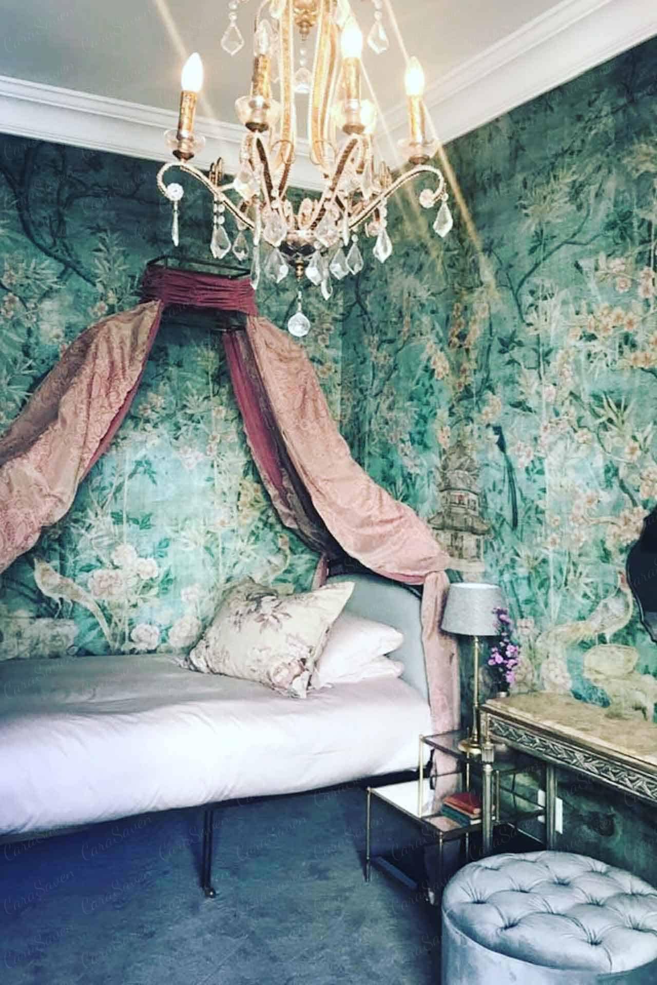 Intricate nature-themed wallpaper showcasing detailed botanical designs with vibrant hues of green, pink, and blue. The wallpaper features flowers, leaves, and delicate vines weaving through the pattern. Highlighted by subtle gold accents to add a touch of elegance. Suitable for creating a serene yet sophisticated atmosphere in a bedroom setting.