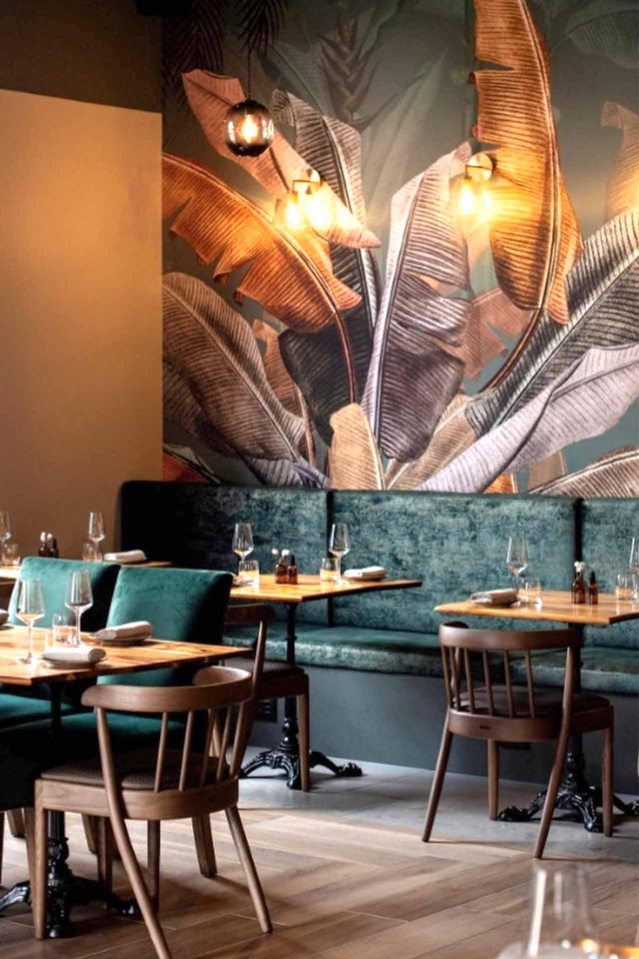 Tropical-themed mural with large plant leaves, green hues, lush foliage, varied shades of green, botanical patterns.