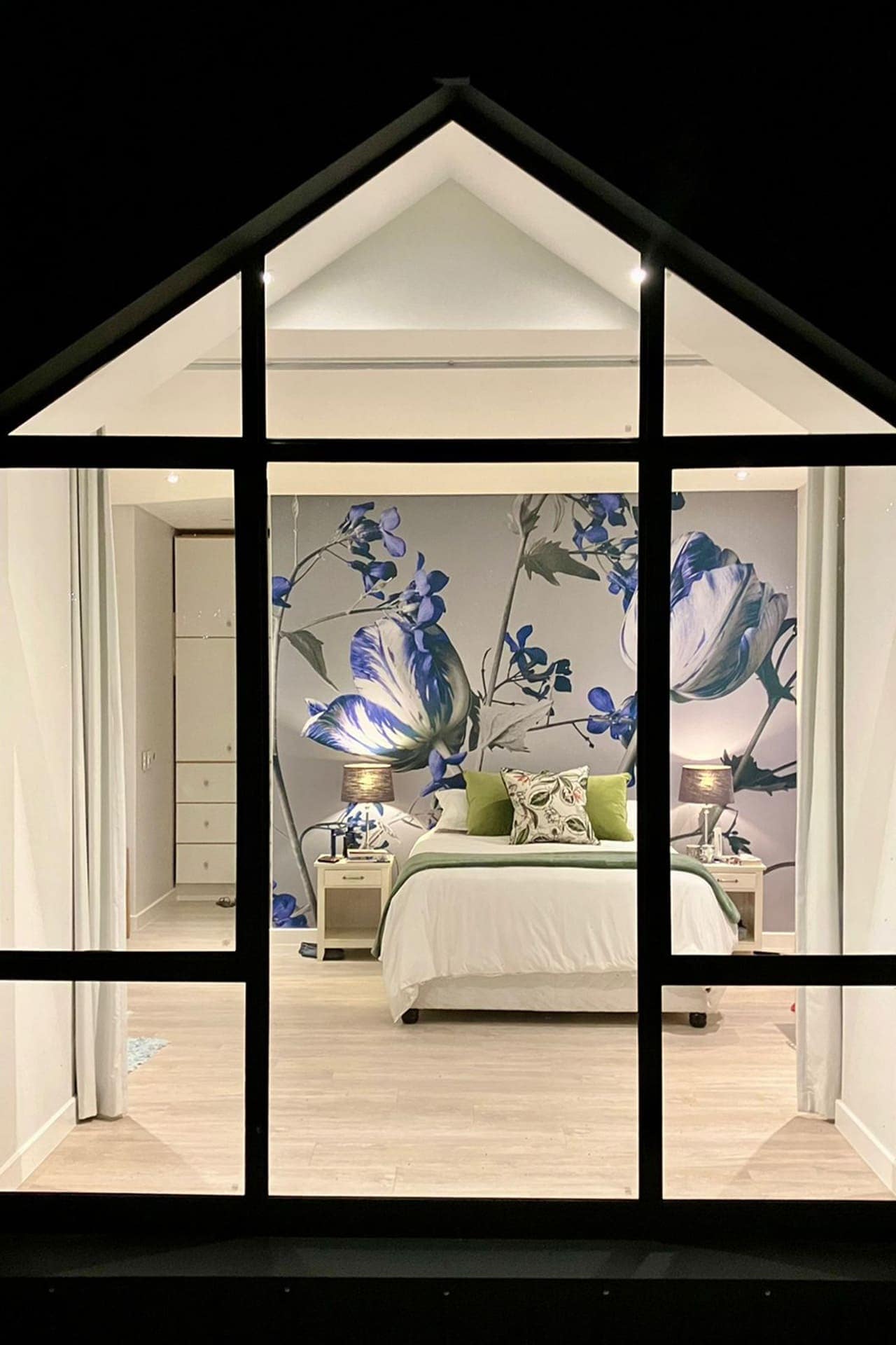 A blue and white flower mural on a gray wall.