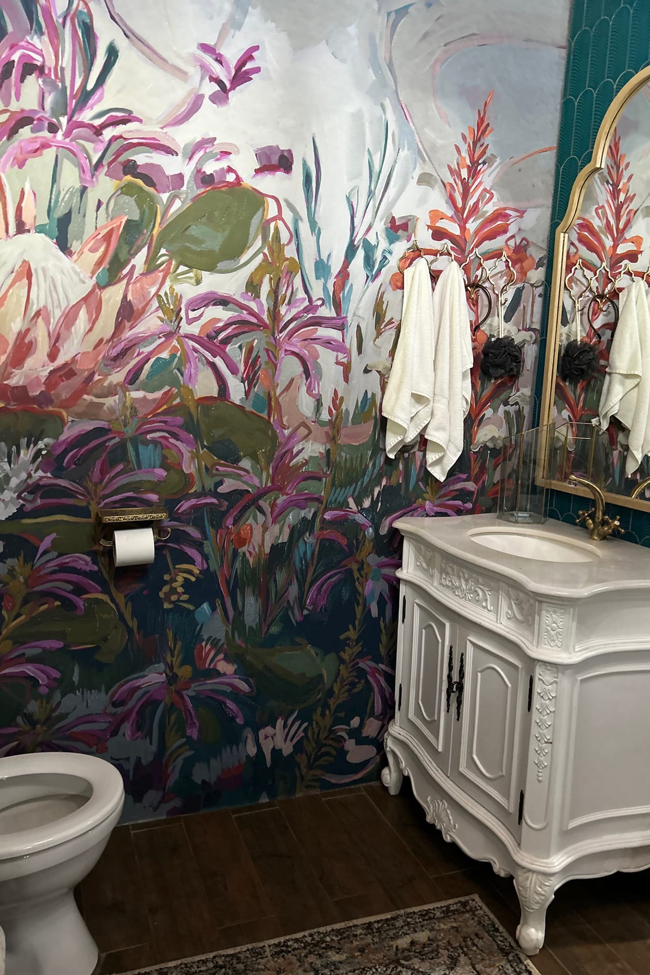 The walls feature a vibrant floral mural showcasing an array of blooming flowers in shades of pink and green. Spiraling vines and leaves intertwine, bringing depth to the design. Accents include soft whites and hints of yellow, adding contrast to the lush botanical pattern. The lifelike detail captures nature’s essence with elegant petals and bursts of verdant foliage, creating a lively, refreshing atmosphere.