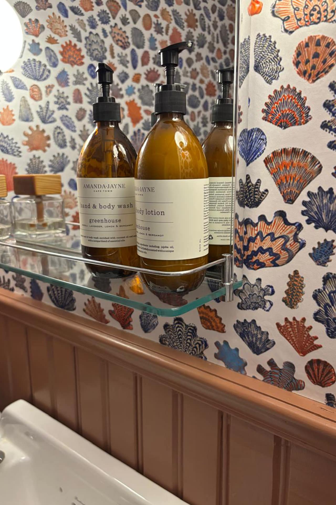 Seashell-patterned wallpaper featuring vibrant colors such as turquoise, coral, and sandy beige.