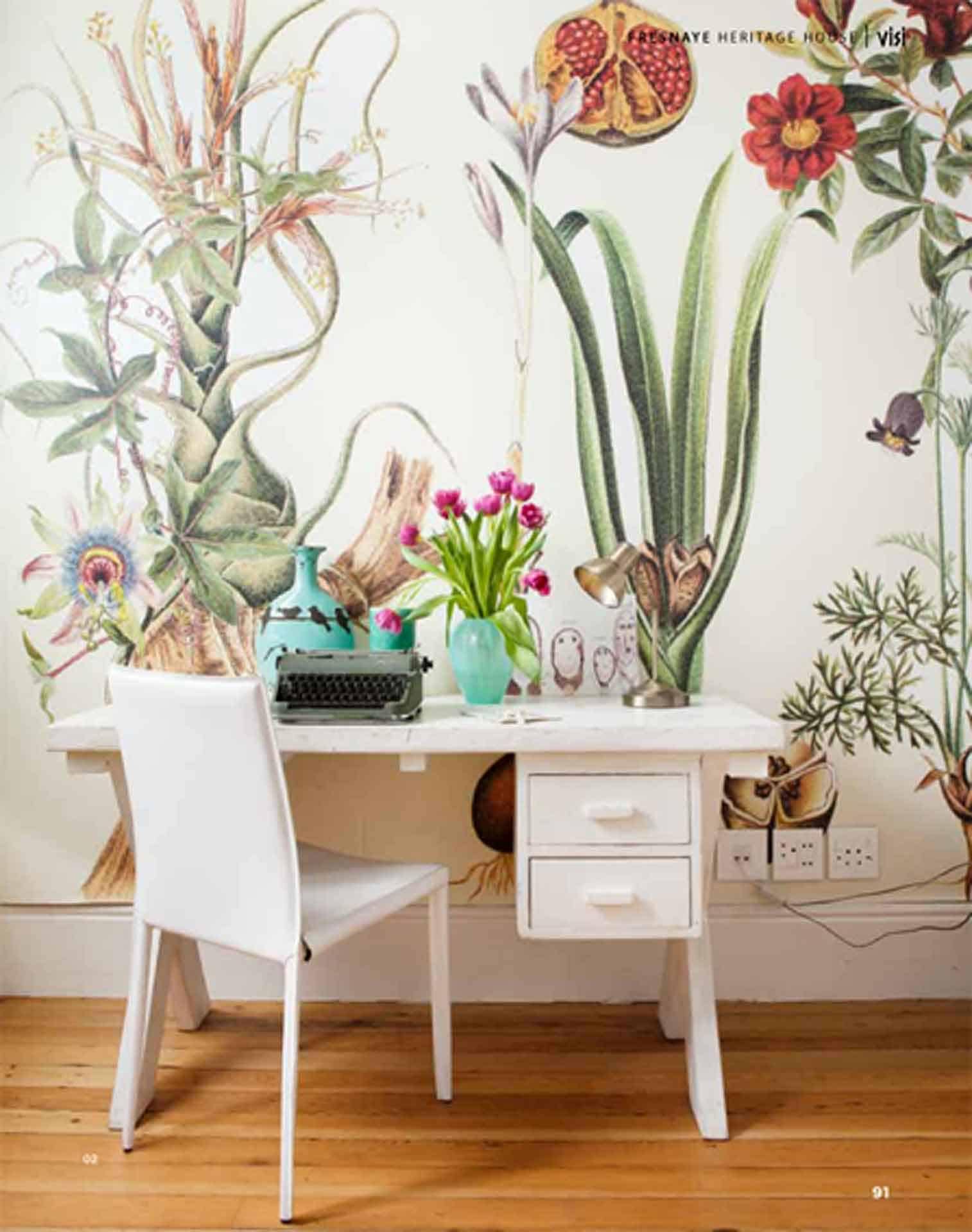 The wallpaper features large botanical illustrations with lush green leaves, intricate tropical plants, and vibrant floral patterns in hues of pink, yellow, and white.
