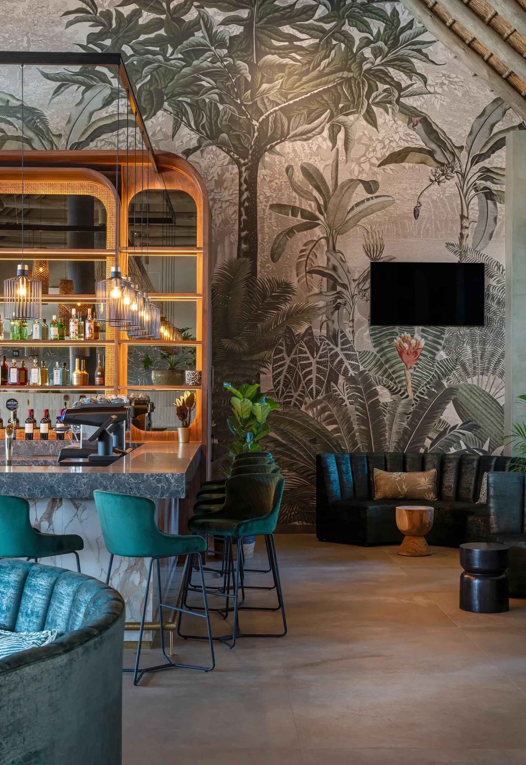 Tropical jungle mural wallpaper featuring lush green leaves, palm fronds, and vibrant botanical elements in various shades of green with touches of yellow and brown.