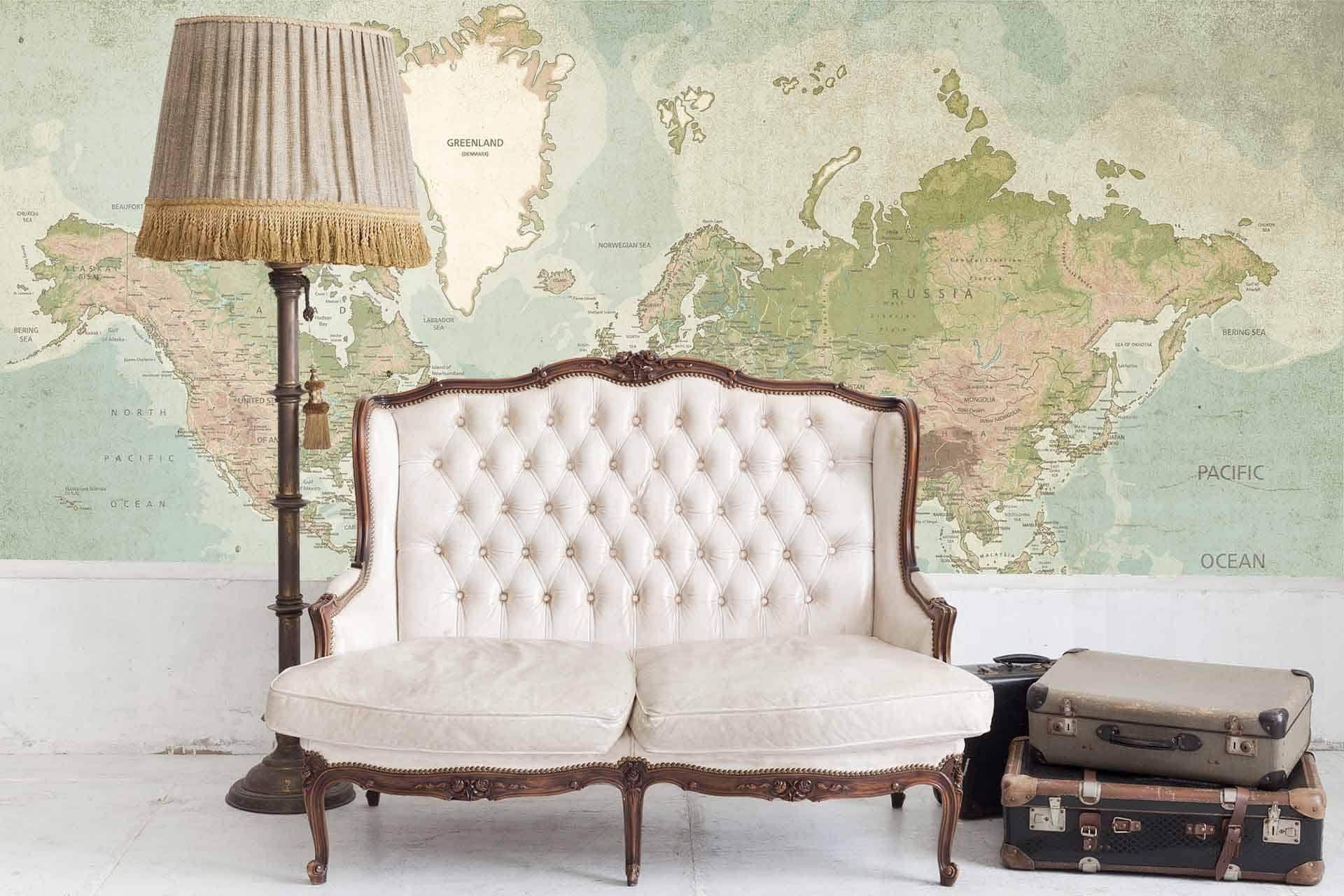 The wallpaper showcases a large world map mural in green and beige tones. The details include vintage cartography with intricate lines and various shades of emerald, olive, sage, cream, and tan.