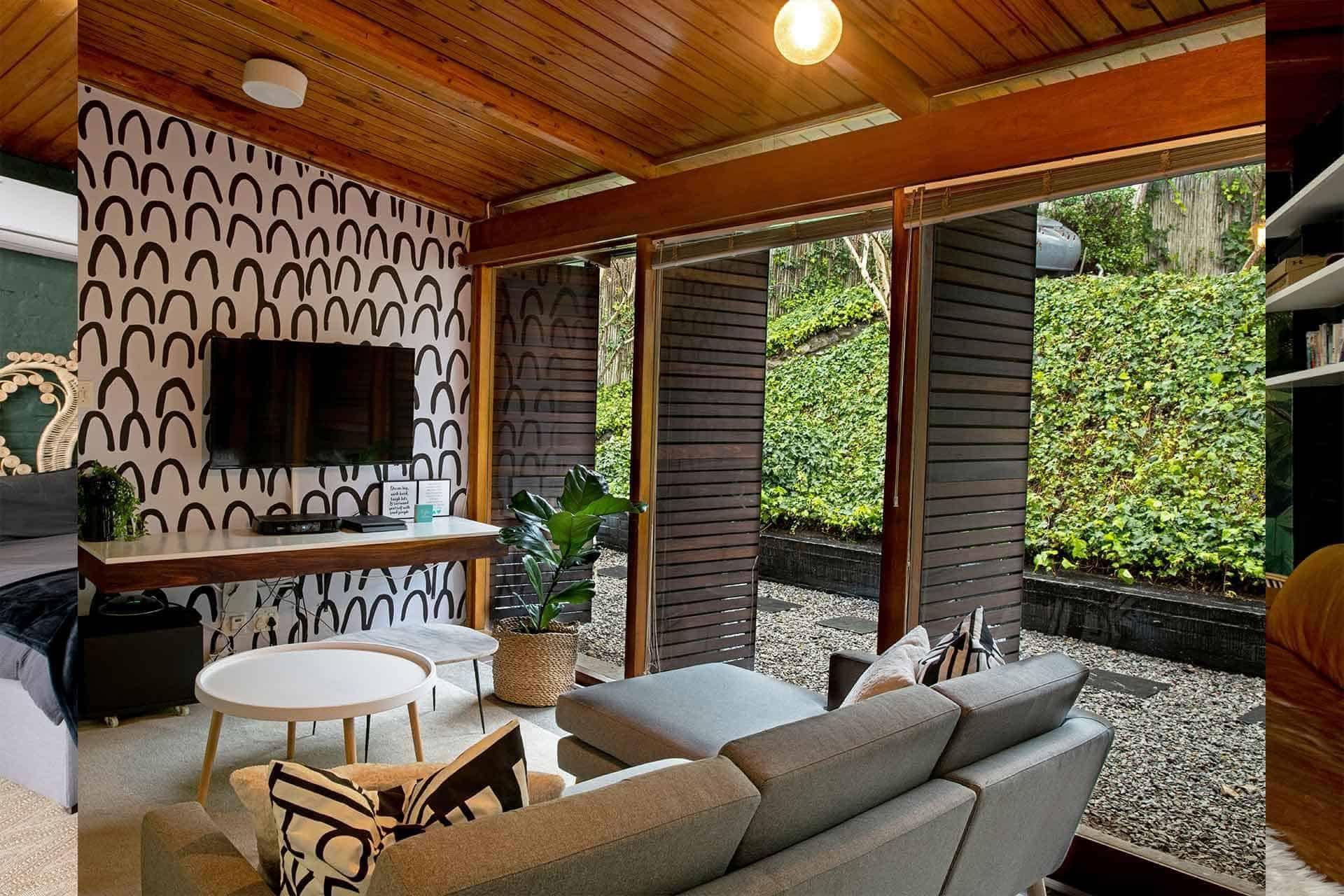 The wallpaper in the cozy living room features black arches, creating a bold and stylish pattern. The interplay of dark tones against the light backdrop adds depth and character to the space. Perfect for enhancing contemporary designs with its striking yet sophisticated look.