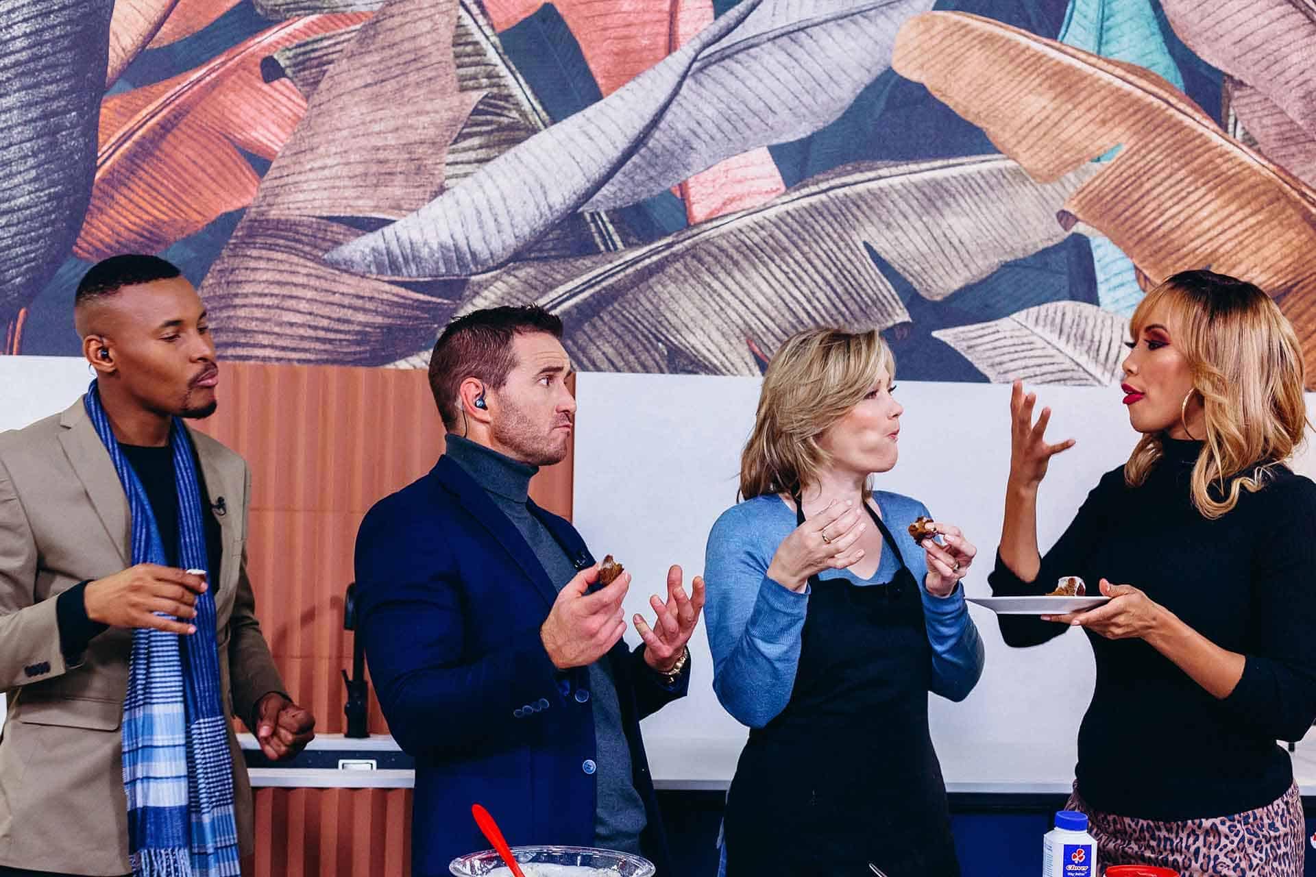 A large leaf mural on the wall features various shades of green with intricate vein details. The leaves are depicted in different sizes and orientations, creating a lush, layered look. Hints of yellow and brown accents add depth to the foliage.