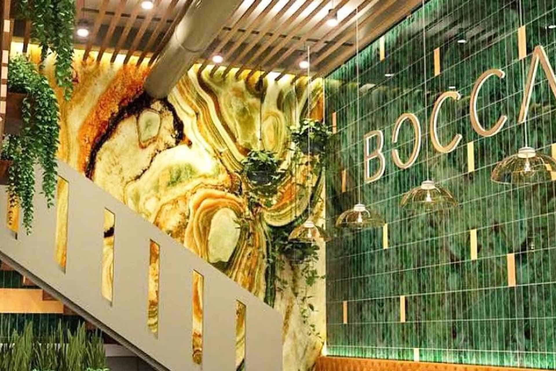 Green and yellow marble patterns dominate the accent wall, creating a visually striking backdrop. The wallpaper features a mix of deep green and vibrant yellow hues, accented with intricate veining. This blend of colors evokes luxury and sophistication, making it suitable for refined spaces like those associated with financial planning excellence, as suggested by "BOSCA.