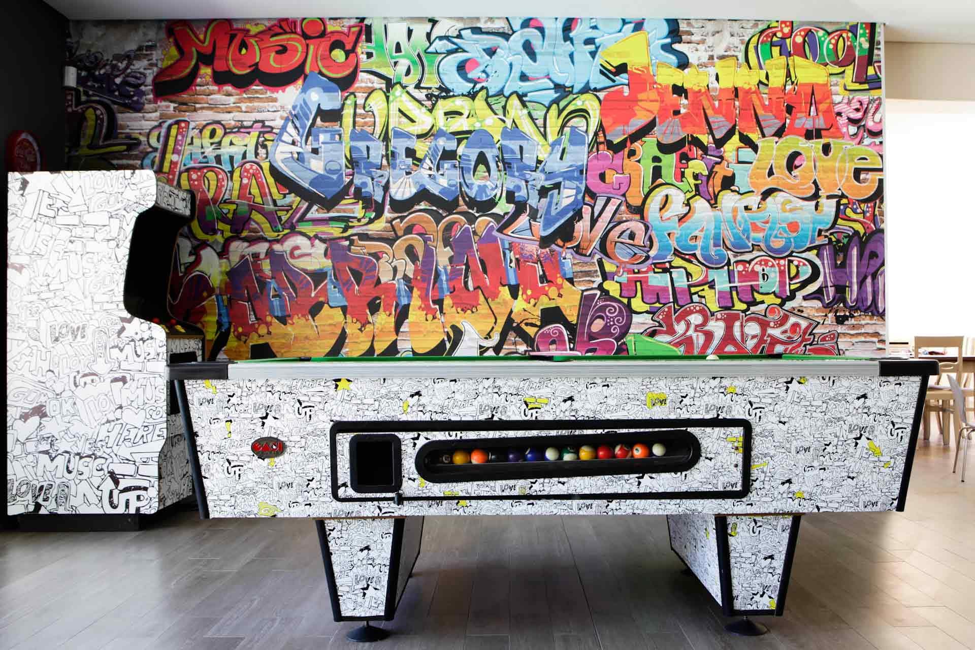 The wallpaper is vibrant and graffiti-covered, featuring a mix of bold, multicolored fonts with various words and tags. It includes bright hues and contrasting shades that add an artistic flair, ideal for showcasing in an artist's portfolio.