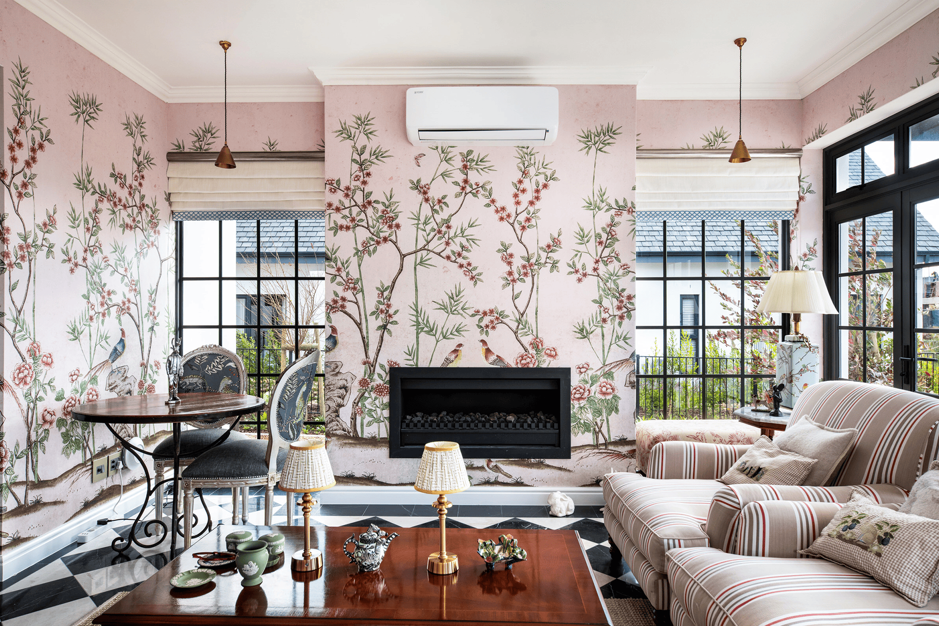 Floral pink wallpaper with delicate blossoms and greenery. Shades of blush, rose, and soft green create a sophisticated yet vibrant backdrop. Peonies, roses, and intricate leaf patterns bring elegance to the modern living room setting. Perfect for adding a stylish touch to any interior design portfolio.