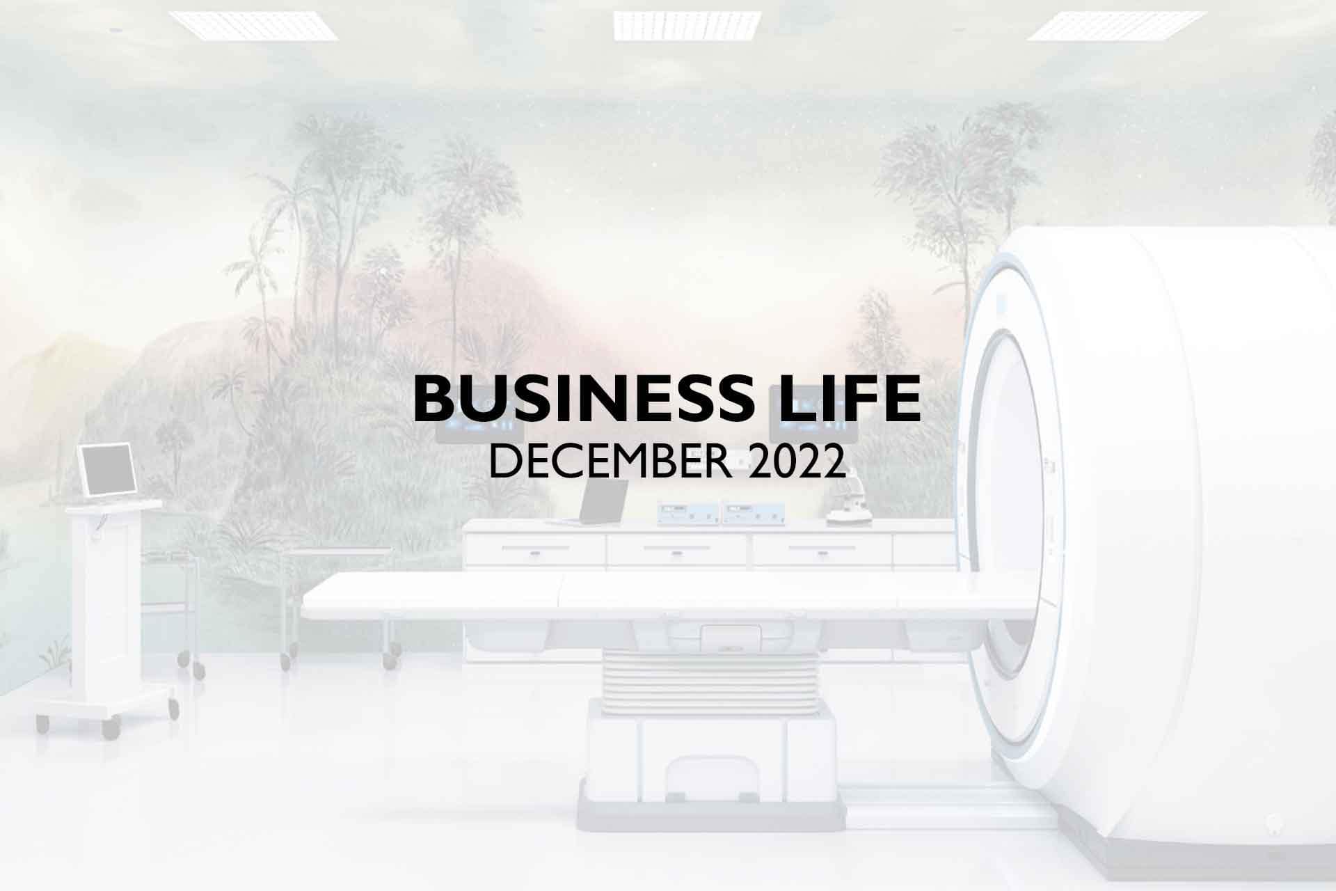 A scenic background featuring a medical imaging room with an MRI machine takes the forefront in this image. The wallpaper showcases sleek, modern medical technology elements interwoven with business motifs. Predominant colors include clinical whites, neutral grays, and soft blues. "BUSINESS LIFE DECEMBER 2022" is prominently displayed in bold black text above the machine, adding a professional touch to the scene.