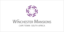 The Winchester Mansions wallpaper features a purple circular motif, elegant script reading "Winchester Mansions," accompanied by "Cape Town South Africa" in refined text. The design evokes a sense of inviting warmth and home-like essence, distinguished by its unique carousel theme. Key elements are the purple circular design and sophisticated typography.