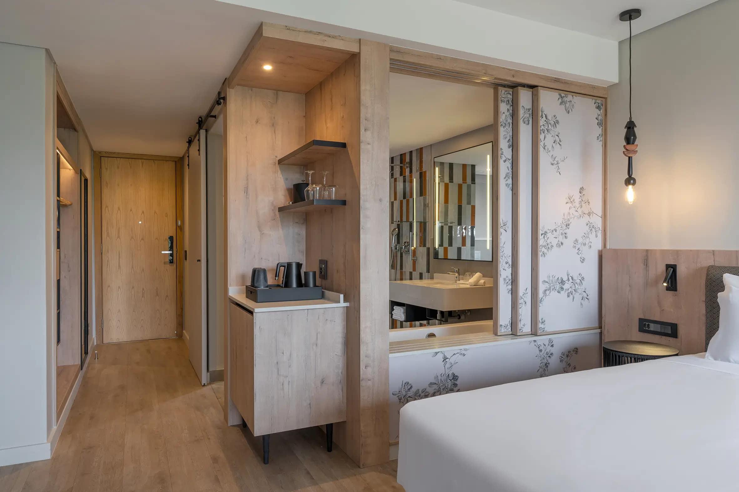 Floral wallpaper with lush green and pastel botanical patterns, featuring leafy vines and delicate blooms in soft pink, white, and gold tones—key decorative element of Radisson Safari Hotel Hoedspruit’s modern rooms.