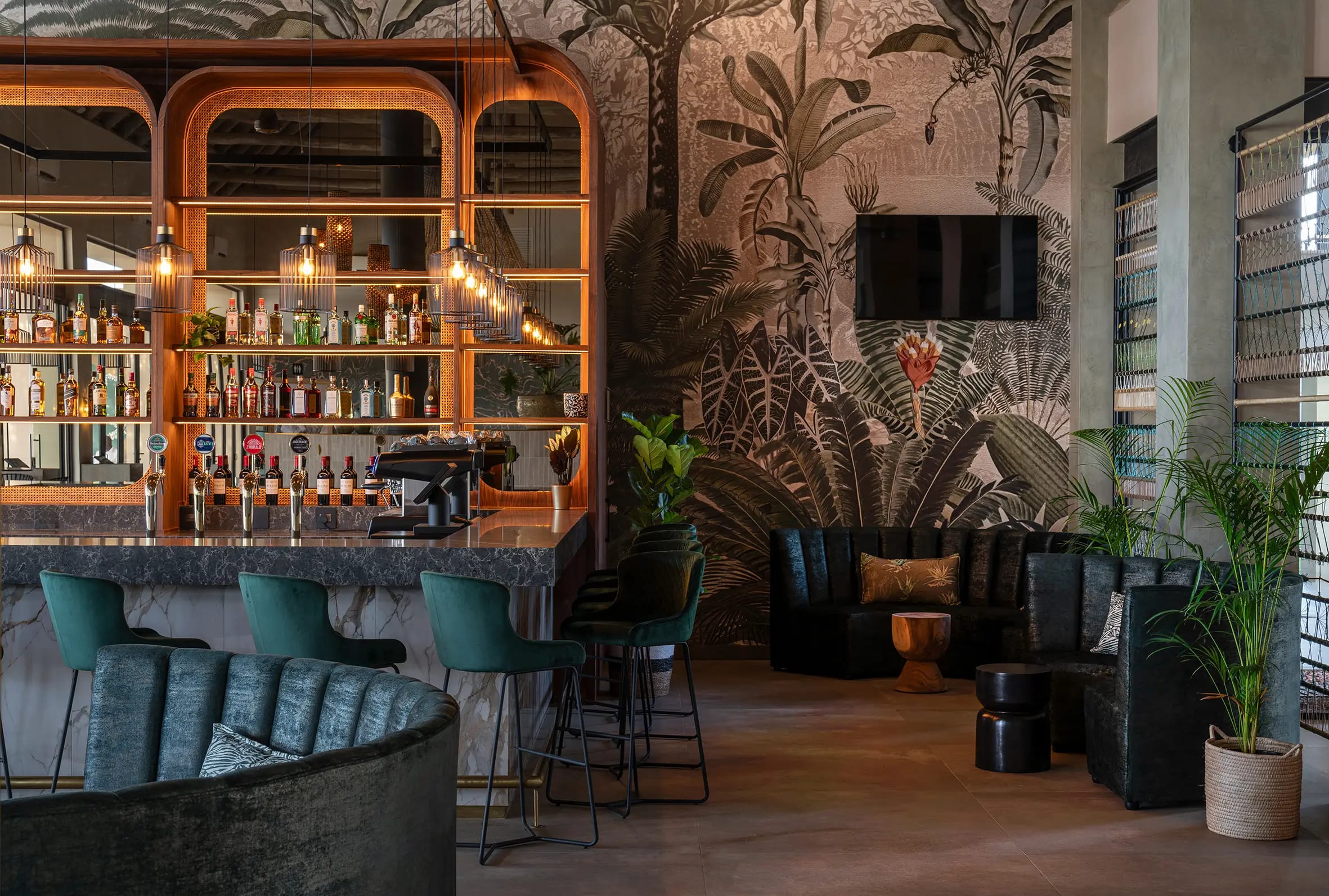 Large tropical-themed wall mural featuring lush green palm leaves, vibrant exotic flowers in shades of pink and orange, and detailed botanical patterns; the wallpaper brings a lively jungle atmosphere with rich greens and colorful accents.