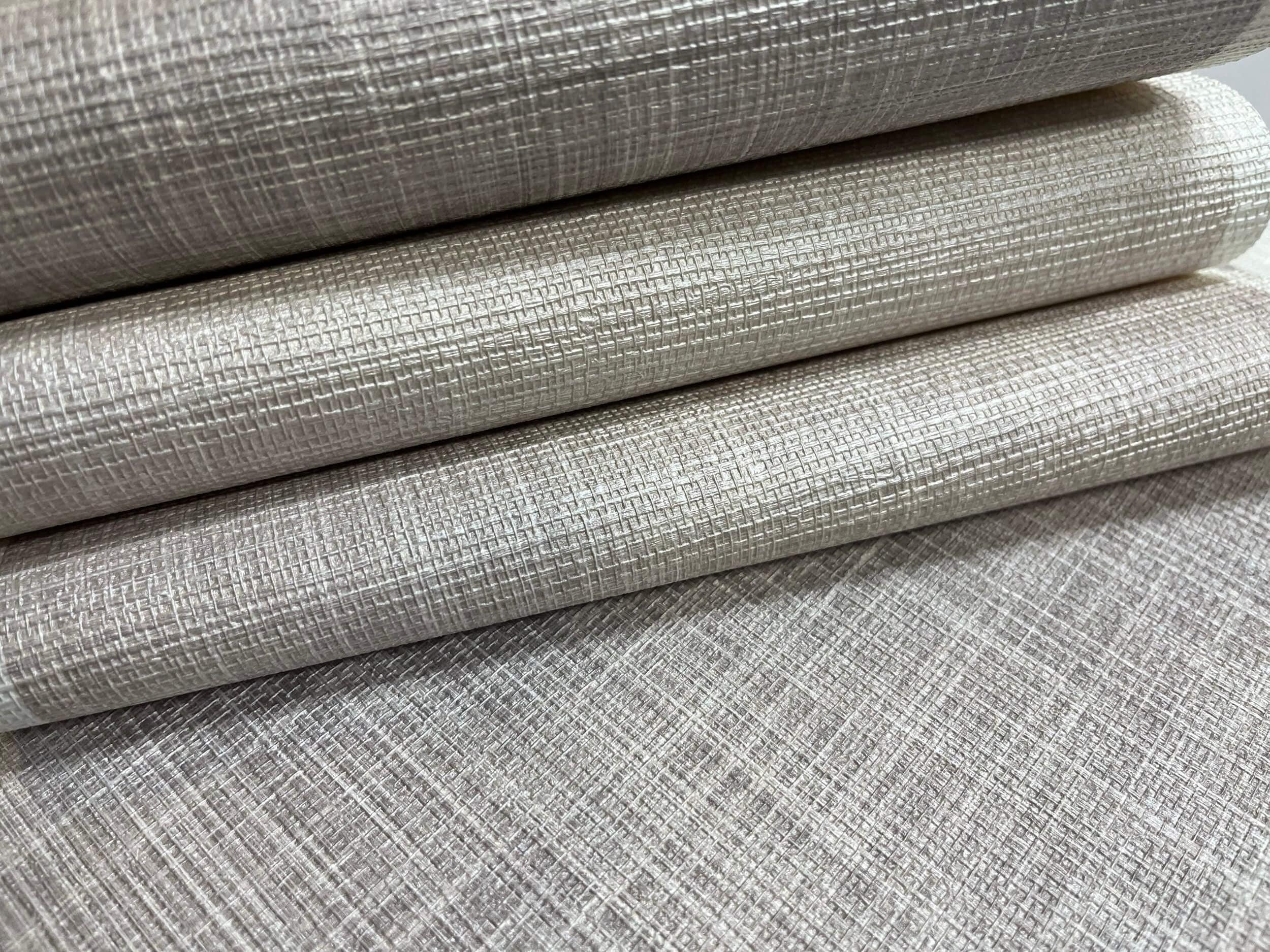 Neutral beige and light gray wallpaper with a subtle crisscross, woven linen-like texture. Features a soft, diagonal pattern ideal for minimalist or modern interiors.