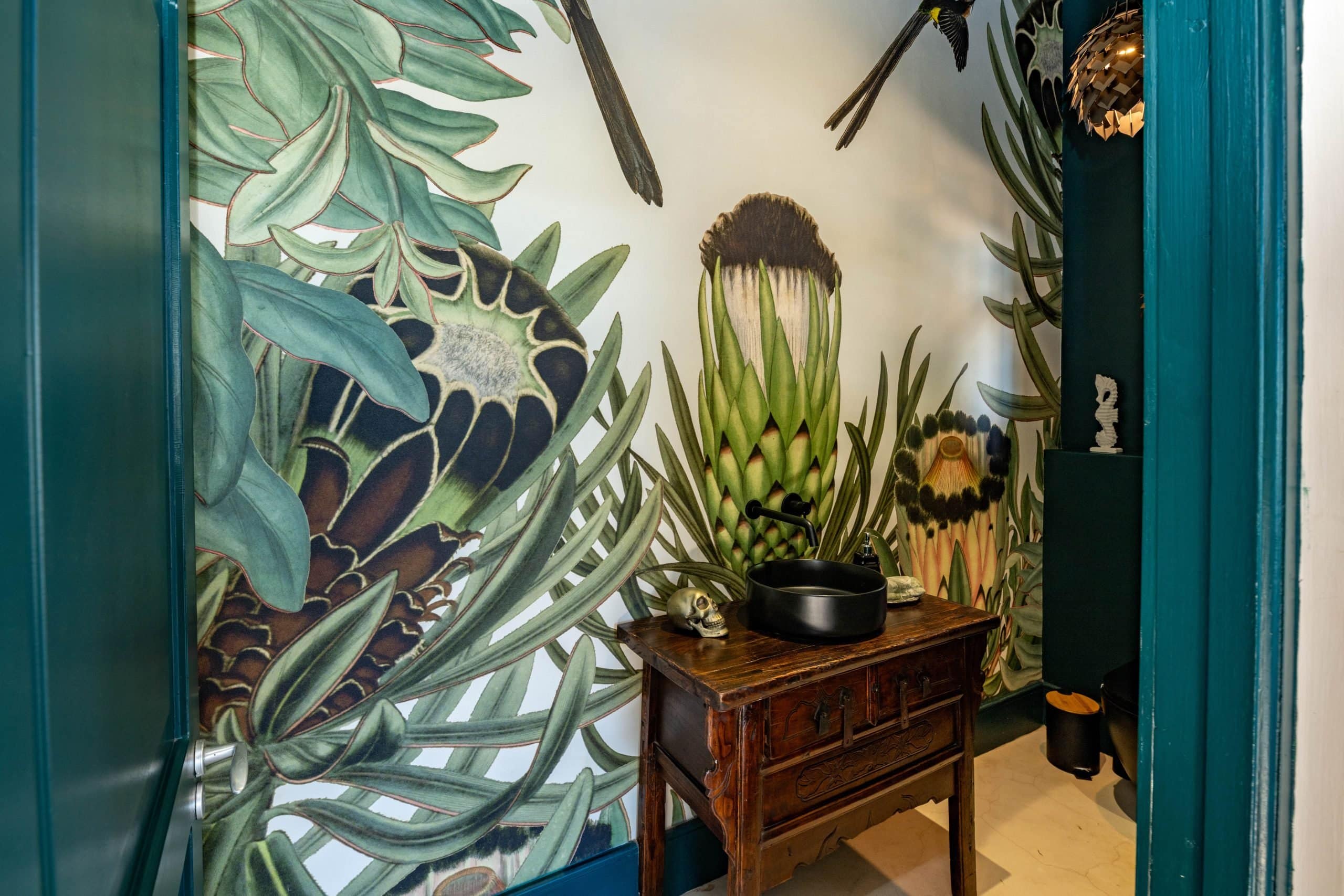 Large, vibrant botanical wallpaper with green leaves and pink protea flowers in bold patterns.