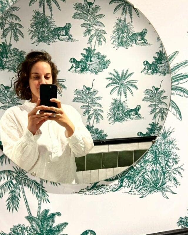 Nature-themed wallpaper adorned with vibrant green illustrations of exotic plants and tigers.