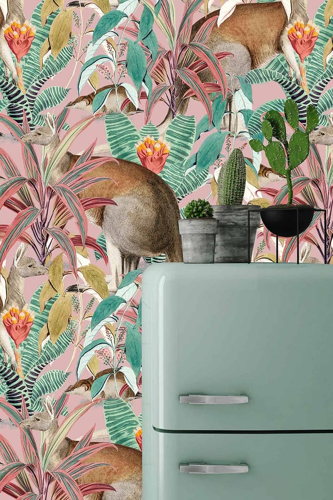 The wallpaper features a vibrant, tropical-themed design with lush green leaves, colorful flowers in shades of pink, orange, and yellow, and subtle yet whimsical hidden deer. The colors are bright and cheerful, creating an eye-catching backdrop. This creates an energetic contrast to the pastel-colored elements in the kitchen scene.