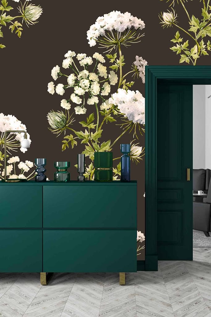 The "Growing Wild" floral wallpaper features large white flowers and lush green leaves, set against a softly toned background. This striking pattern brings a touch of nature indoors with its detailed botanical design and fresh color palette.