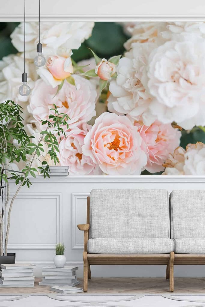 The wall mural features blooming pink and white flowers, reminiscent of a rose garden. The colors are soft, pastel tones creating a relaxing and inviting atmosphere. Elements include large roses and delicate petals.
