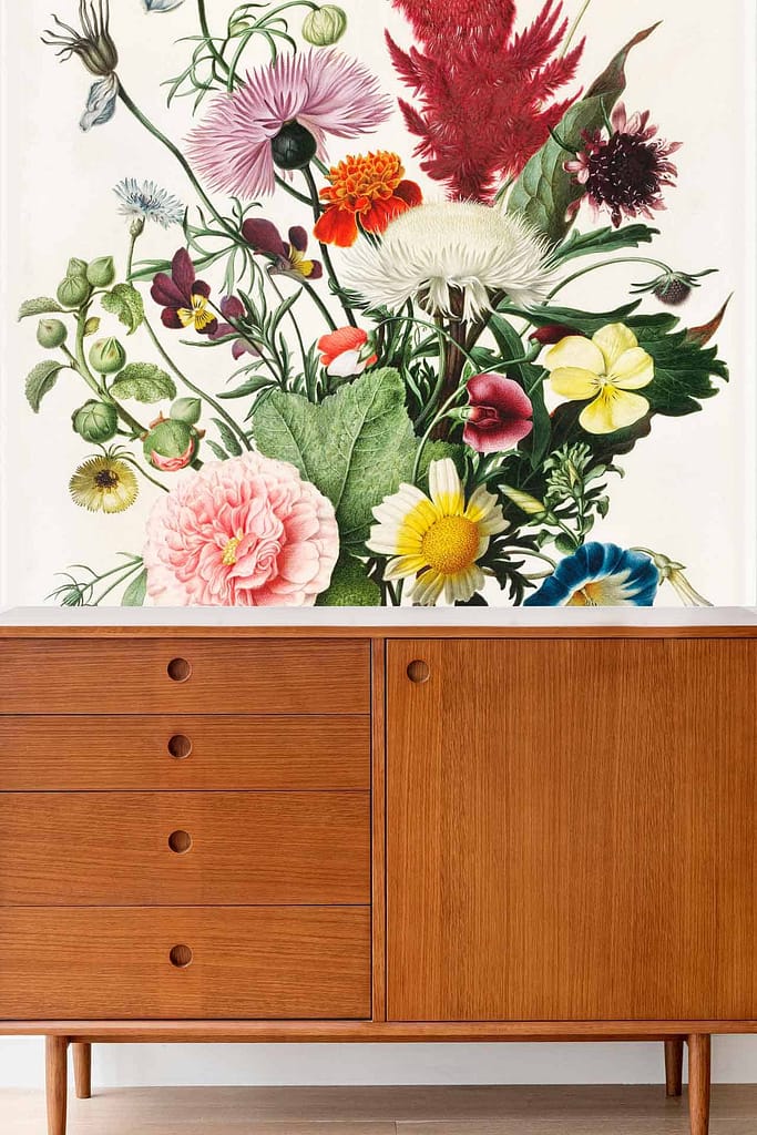 The wallpaper is a vibrant floral mural featuring an array of colorful posies and green foliage. It includes a variety of hues such as reds, pinks, yellows, blues, and greens, creating a lively and artistic backdrop.