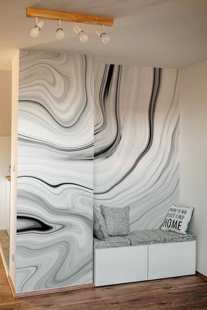 Striking wall mural featuring swirling marble-like patterns in black, white, and gray. Bold lines and fluid shapes create a dynamic yet sophisticated design.