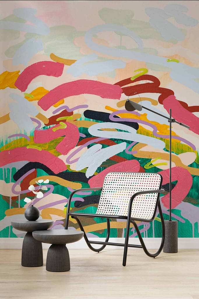A modern room features a colorful abstract mural with bold, swirling brushstrokes in various shades of pink, red, green, and blue.