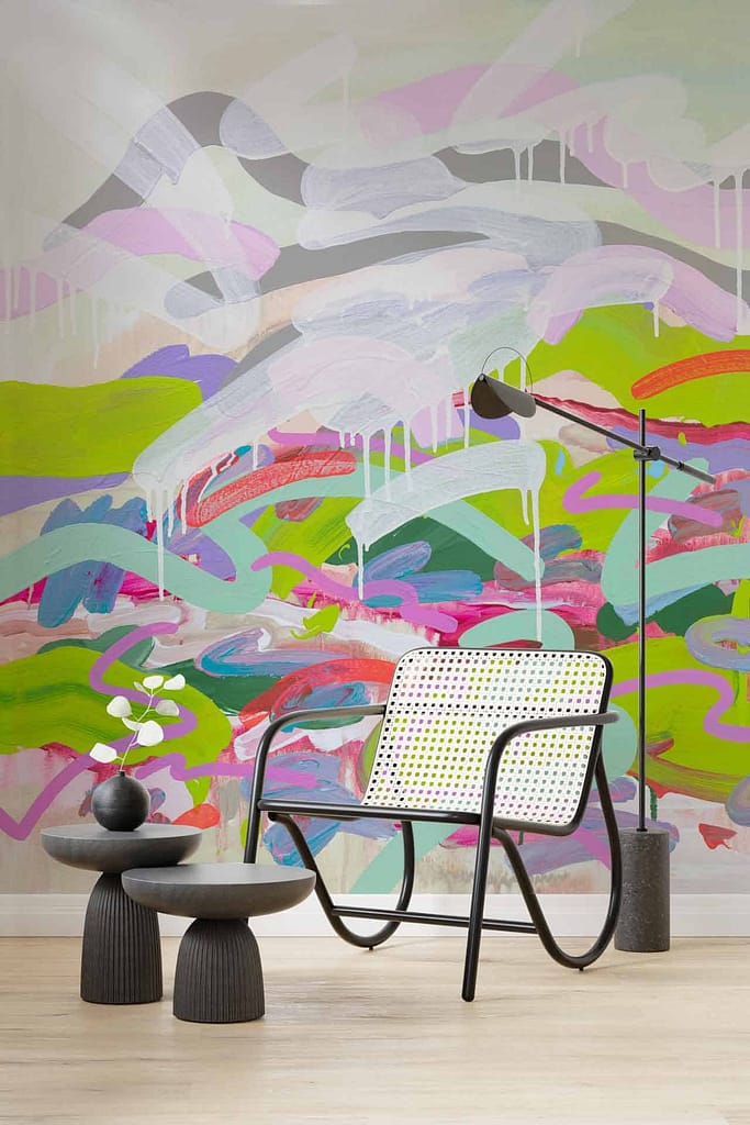 Modern interior wallpaper featuring a colorful abstract mural with bold brushstrokes in green, pink, and purple tones.