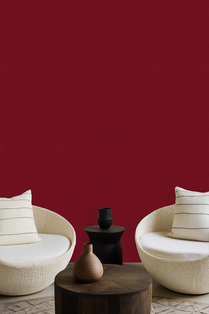 The wallpaper features a bold, vibrant red color, reminiscent of a lively wine region. It provides a dramatic backdrop that enhances the room's minimalistic aesthetic while adding warmth and depth.
