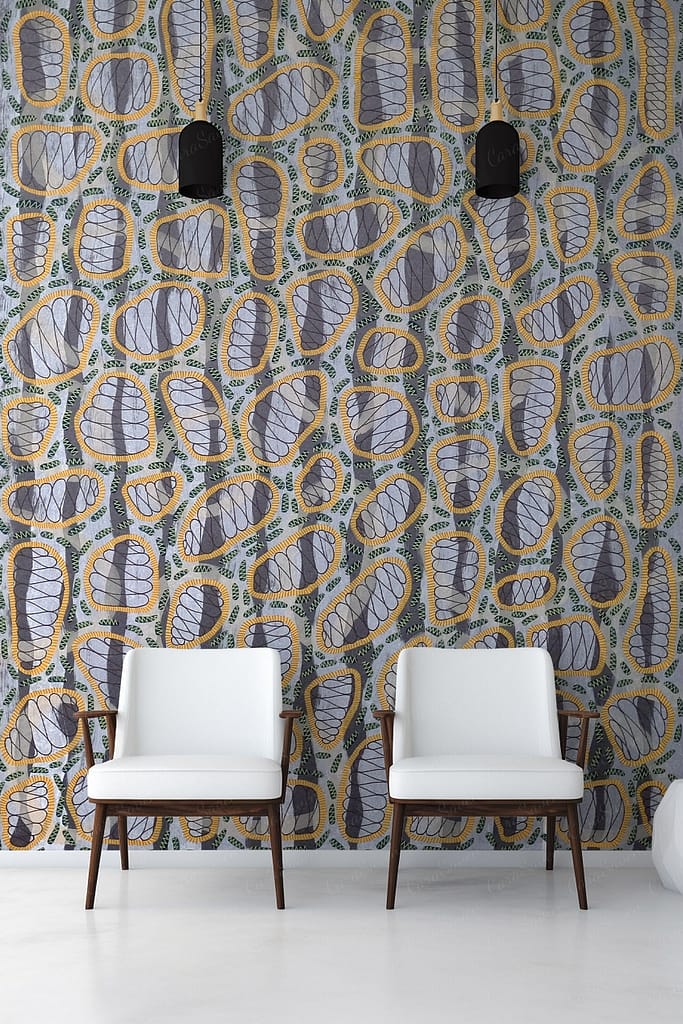 A modern interior features a wall with a colorful abstract pattern consisting of blue, gray, and yellow irregular shapes. This wallpaper stands out with its dynamic combination of colors and abstract elements, making it an eye-catching design choice.