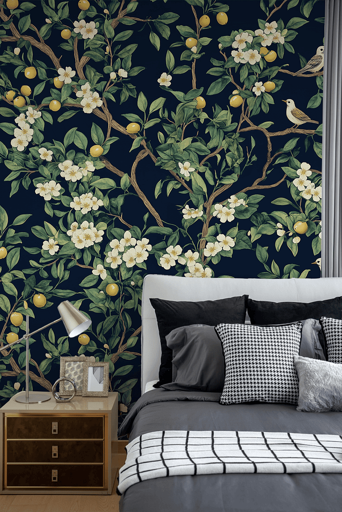 A stylish bedroom featuring a dark floral and lemon wallpaper reminiscent of an Olive Grove. This lush wallpaper showcases intricate patterns of olive branches with deep green leaves, vibrant yellow lemons, and delicate white blossoms on a rich, dark background.