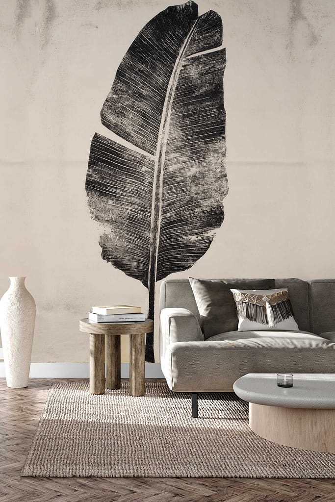 Large black leaf mural wallpaper with bold botanical patterns on a light wall; striking black leaf shapes contrast against a neutral background, creating an Island Imprint effect perfect for tropical or nature-inspired interiors.