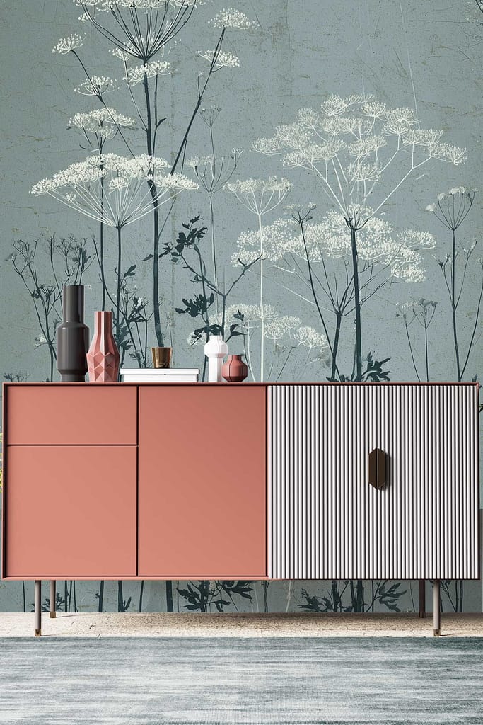 Wallpaper with large botanical illustrations of delicate flowering stems on a muted blue-green background, featuring detailed floral and stem elements in soft, natural tones.