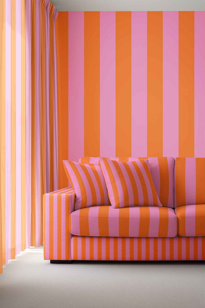 Modern living room wallpaper with bold vertical stripes in pink, orange, and blue; mirrors the color palette of the sofa and curtains. Distinctive striped pattern makes the colorful wallpaper a focal point.