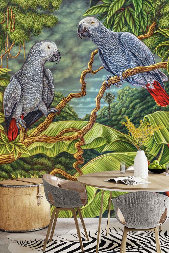 Wallpaper featuring two grey parrots with red tails and a playful tiger amid lush green leaves; colorful mural with vibrant greens, greys, reds, orange, and yellow tones.