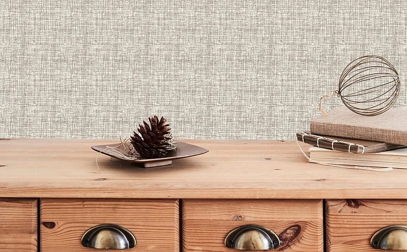 The background features textured, light-colored wallpaper with subtle patterns and gentle hues, adding a soft decorative element to the scene.