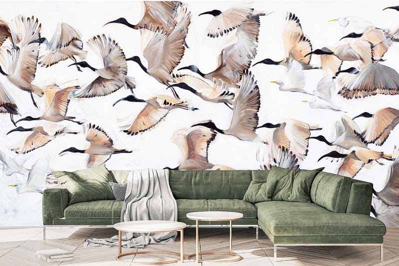 The living room features a mural wallpaper of birds in flight, creating pockets of air and movement. The design includes birds in various motion against a subtle background that blends seamlessly with the modern decor. The colors include shades of blue, white, and grey, enhancing the sense of elegance and dynamic energy.
