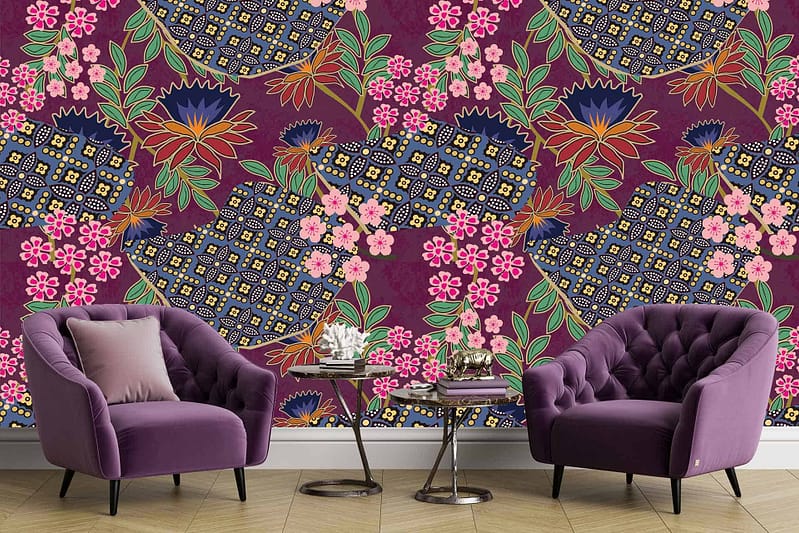 The wallpaper features vibrant batik floral designs in shades of pink, blue, yellow, and green. The richly patterned wall showcases intricate flowers and botanical elements in these bright colors.