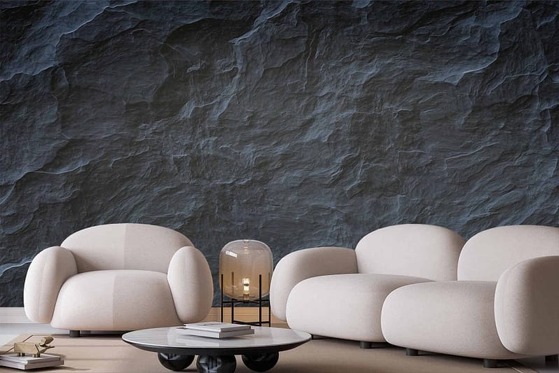 The modern living room features a textured dark stone wallpaper with an intricate pattern. The wallpaper predominantly showcases deep charcoal and black tones, giving a rich and sophisticated look. Subtle flecks of lighter grey add dimension to the stony texture. This dramatic backdrop enhances the room's overall aesthetic, blending seamlessly with its contemporary elements.