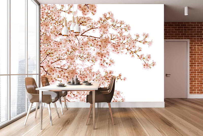 The wallpaper features a vivid cherry tree in full bloom, showcasing delicate pink blossoms and intricate brown branches. The background is a serene sky blue, accentuating the vibrant pink flowers. Subtle white accents mimic falling petals, adding motion to the scene.