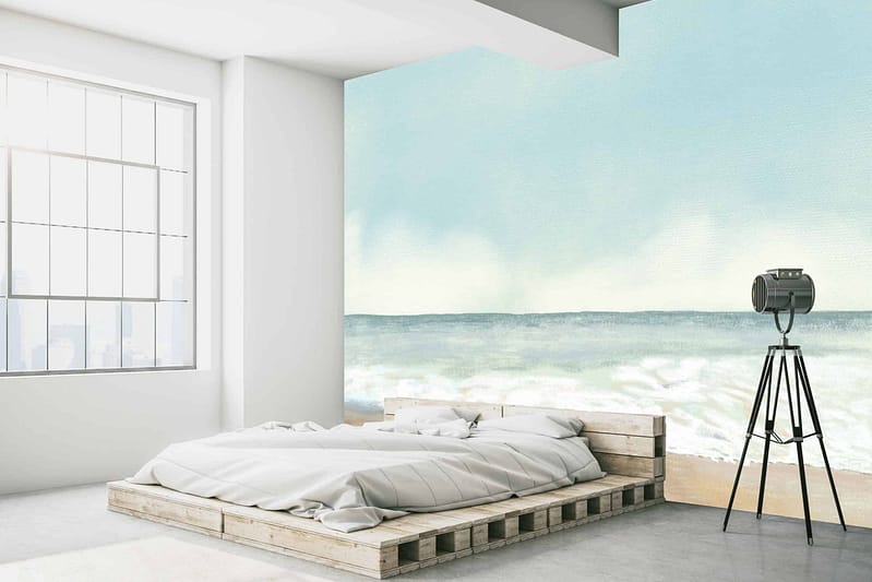 The wallpaper features a large mural of an ocean scene reminiscent of Coney Island. Key elements include waves, a sandy shore, seagulls, and the iconic Ferris wheel in the distance. Predominant colors are shades of blue for the water and sky, sandy beige for the beach, and hints of white for sea foam and birds. The Ferris wheel includes touches of red and yellow.