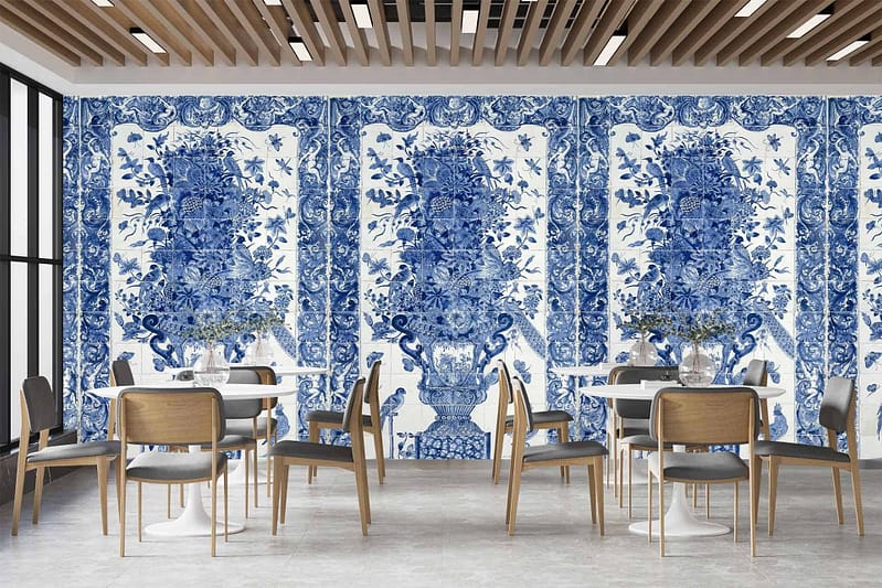 The dining area features a large wall adorned with intricate blue and white floral patterns, reminiscent of traditional French porcelain designs.