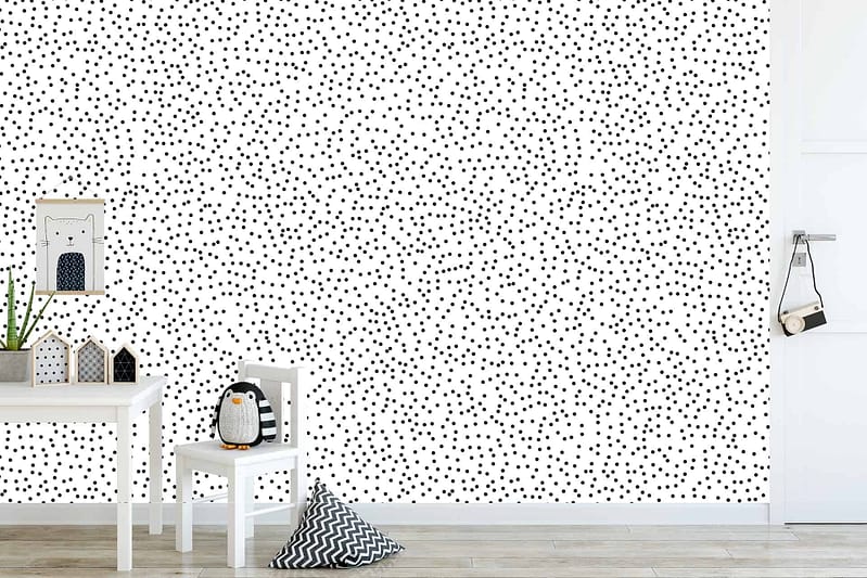 The children's room features a white wall adorned with a charming "Going Dotty" pattern of small black dots. Against the crisp white background, the evenly spaced black dots create a simple yet playful décor. The wallpaper's monochromatic scheme makes it versatile and suitable for various room themes.