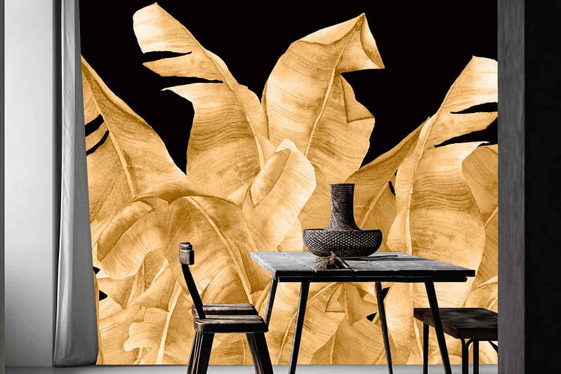 The wallpaper features a bold mural with golden tropical leaves against a black backdrop, creating striking contrast and artistic flair.