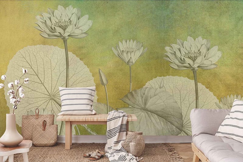 A large wall mural featuring oversized green lotus flowers and leaves set against a sunset-colored gradient background. The wallpaper highlights vibrant greens in the floral designs, complemented by warm shades of orange, pink, and purple in the gradient backdrop.