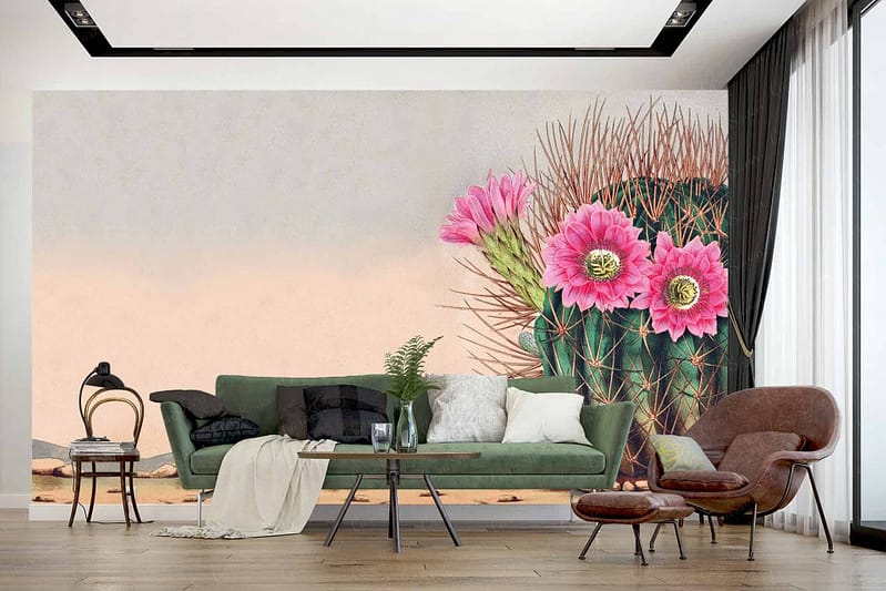 A modern living room wallpaper features a large mural of a cactus adorned with blooming pink flowers, incorporating elements of desert wilderness. Key colors include green from the cactus, vibrant pink from the flowers, and earthy tones.